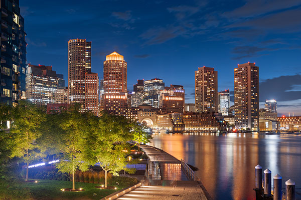 Boston-MA-city-with-river-in-front-and-trees-with-sidewalk-along-water-to-show-walkway-with-next-generation-9-1-1-technology-implemented