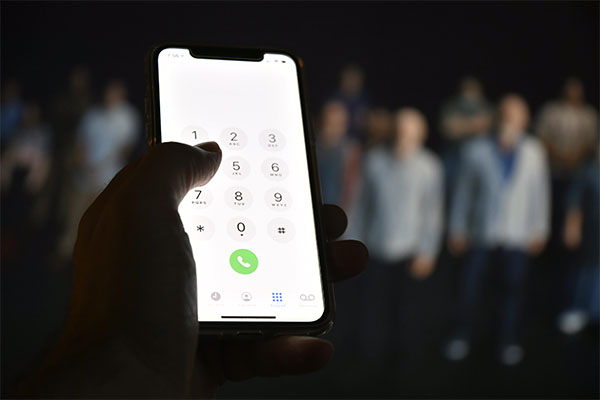 hand-holding-iphone-with-number-pad-lit-up-on-screen-to-compare-next-gen-911-to-smart911