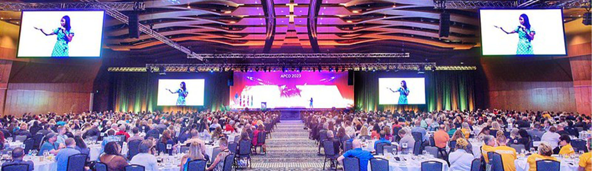 large-conference-room-with-rgb-lighting-and-large-monitors-with-lots-of-people-listening-to-speakers-on-next-gen-9-1-1-technology