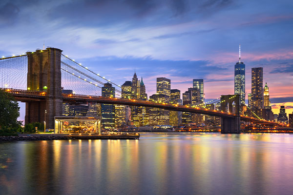 new-york-city-skyline-with-bridge-over-water-at-dusk-which-is-city-where-synergem-technologies-attended-a-conference-for-next-generation-9-1-1-technology