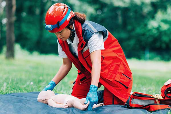 training-event-for-next-gen-9-1-1-professionals-girl-is-saving-dummy-in-open-field-with-safety-gear-on