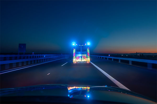 car-following-ambulance-with-blue-flashing-lights-responding-to-emergency-using-next-generation-9-1-1-emergency-response-support