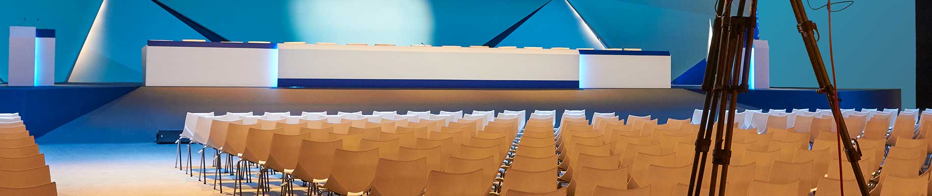 empty-chairs-organized-in-rows-with-stage-in-background-prepped-for-Florida-NENA-conference-where-next-generation-911-speaking-engagements-will-be-held