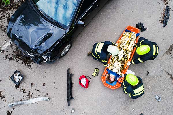 next-generation-9-1-1-technology-in-action-car-accident-scene-with-first-responders-huddled-around-a-stretcher