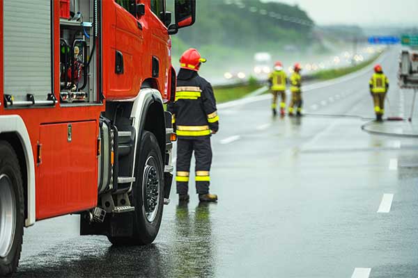 firefighter-standing-next-to-firetruck-on-the-road-dealing-with-emergency-situation-with-next-generation-911-technology