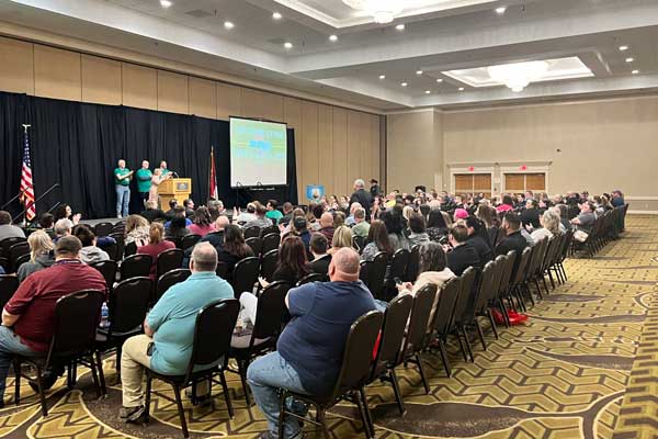 room-with-ng9-1-1-public-safety-workers-listening-to-people-on-stage-talk-about-the-future-of-next-generation-9-1-1-in-large-conference-hall