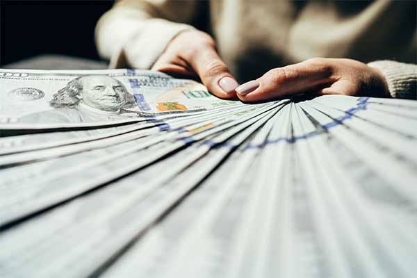 someone-fanning-out-100-dollar-bills-showing-expensive-cost-for-esinet-which-can-be-reduced-with-the-help-of-government-funding-and-other-options-with-ng911