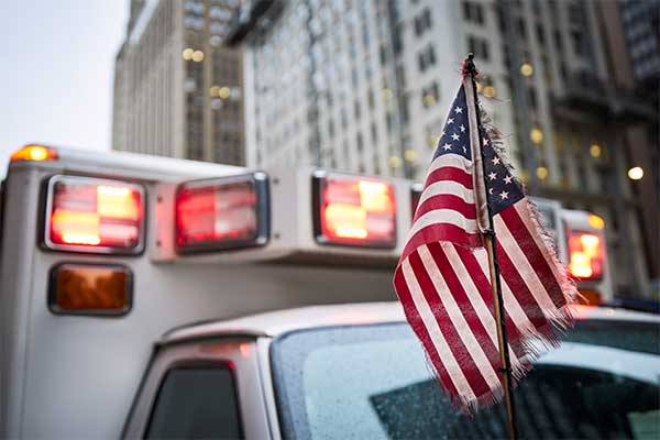 ambulance-with-sirens-activated-and-american-flag-for-esinet-next-gen-911