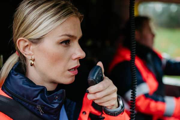 blonde-woman-first-responder-riding-passenger-seat-on-route-to-emergency-which-was-called-in-using-ng911-techonology-set-up-by-psap-next-gen-vendors